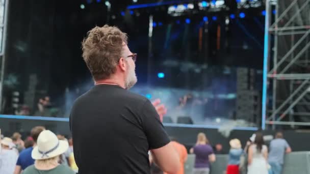 Человек аплодирует на музыкальном фестивале под открытым небом — стоковое видео