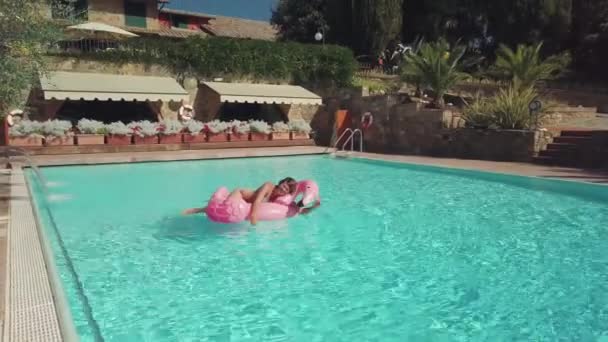 Pembe flamingo ile eğlenen genç kadın — Stok video