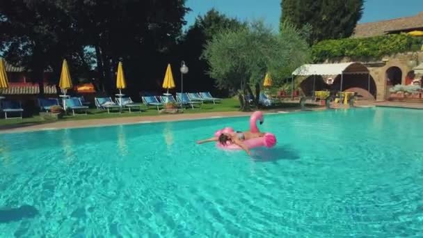 Junge Frau entspannt sich im Pool — Stockvideo