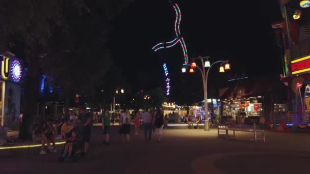Turisté se na vyjížďky v zábavním parku baví. — Stock video