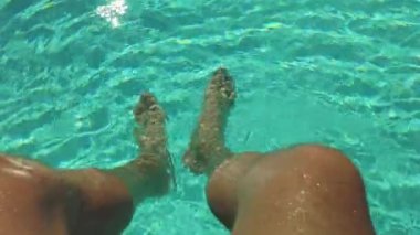 Ayaklarını havuzda dinlendiren adam