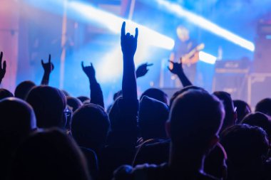 Canlı rock müzik konserinde müzisyenleri sahnede alkışlayan hayranlar