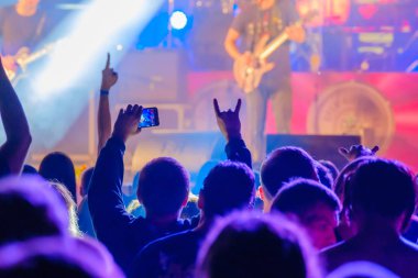Canlı rock müzik konserinde müzisyenleri sahnede alkışlayan hayranlar
