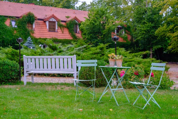 Two outdoor chairs stand on the grass