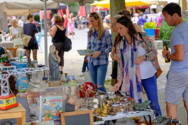 Adam bit pazarında eski antika şeyler satıyor.