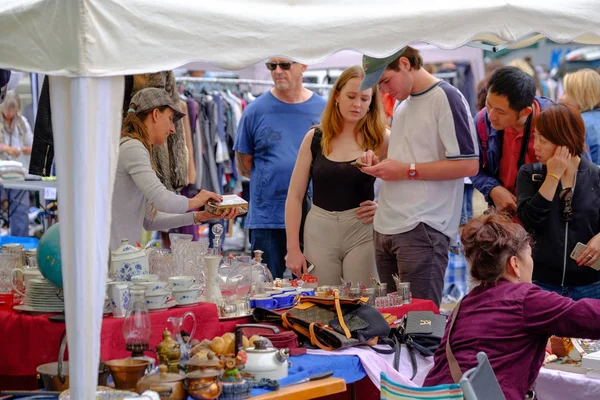 Man sells old antique things at a flea market — Stock Photo, Image