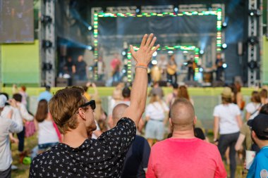 Çift açık hava müzik festivalinde konser izliyor