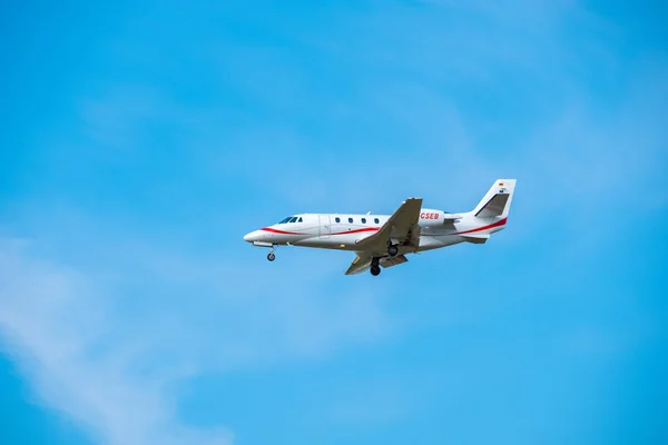 เครื่องบินเจ็ตส่วนตัวขนาดเล็กเตรียมการลงจอดในเวลากลางวันในสนามบินนานาชาติ — ภาพถ่ายสต็อก