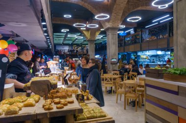 İnsanlar pastaneden taze hamur işi alıyor.