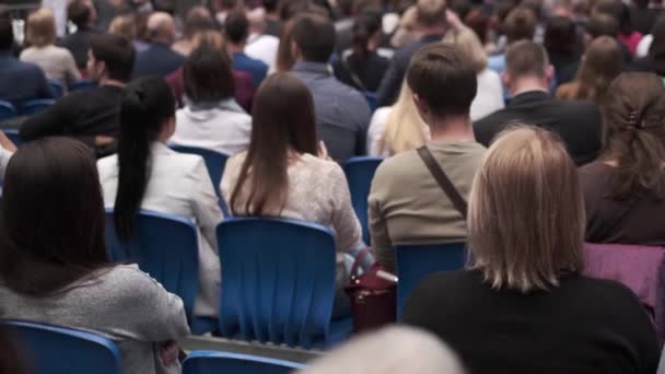 Business conference attendees sit and listen — Stock Video