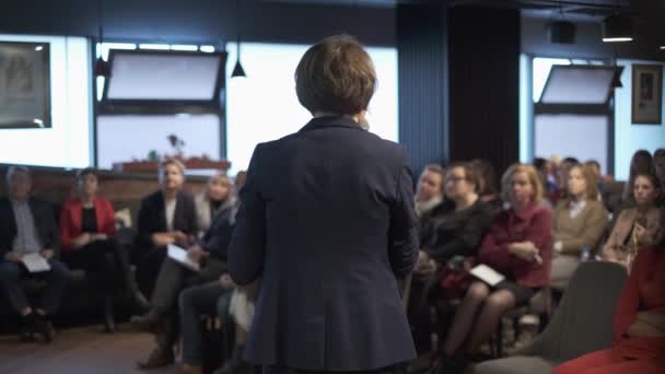 Vrouwelijke presentator spreekt publiek toe — Stockvideo