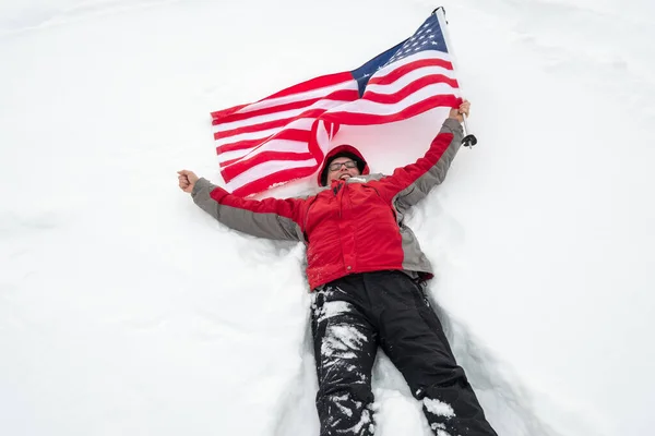 One man hold US flag lies in the snow — Stock Photo, Image