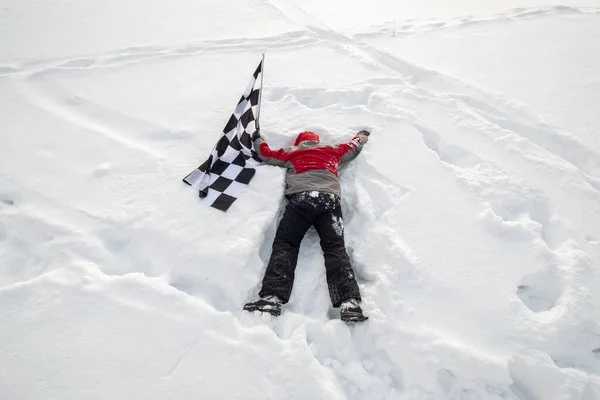 L'uomo giace nella neve con il traguardo — Foto Stock
