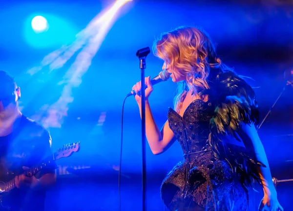 Chica cantante canta en el escenario sosteniendo micrófono — Foto de Stock