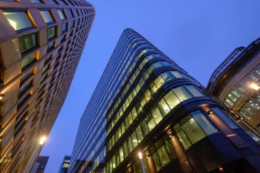 Akşam gökyüzüne karşı aydınlatılmış modern bina
