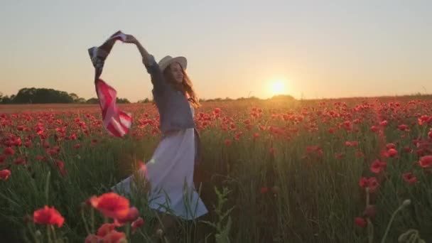 Glad kvinna dansar och viftar USA flagga i fält — Stockvideo