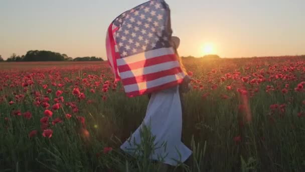 Dospělá žena tančí s vlajkou USA na makové louce — Stock video