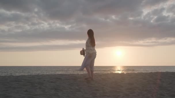 Vrouw dansend tegen bewolkte zonsondergang hemel — Stockvideo