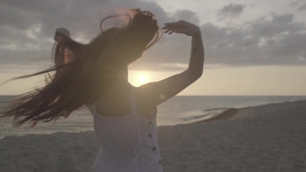 Oigenkännlig kvinnlig rumpling hår på stranden på kvällen — Stockvideo