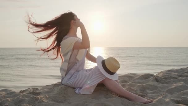 Rozkoszna kobieta odpoczywająca w pobliżu morza podczas zachodu słońca — Wideo stockowe