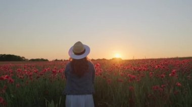 Gün batımında yaprak atan isimsiz bir kadın.