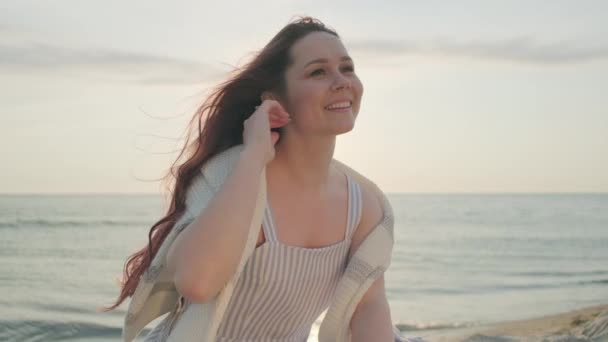 Gelukkig vrouw genieten van winderige avond op het strand — Stockvideo