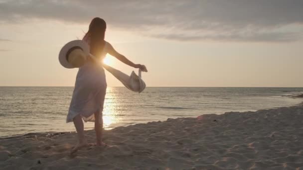 Verrukte vrouw draait rond op het strand in de avond — Stockvideo