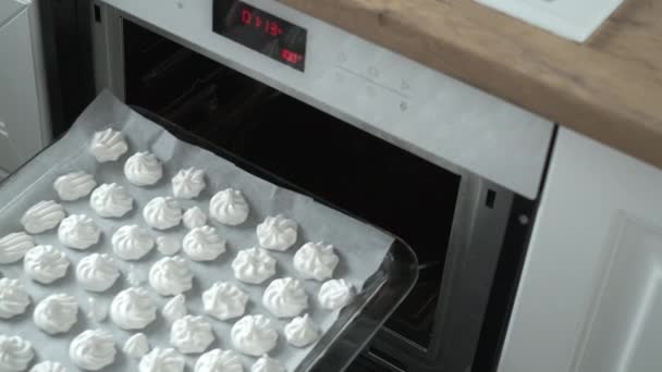 Plantaardige huisvrouw zetten meringues in oven — Stockvideo