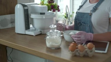 Ekin kadın karıştırıcıya malzeme ekliyor.