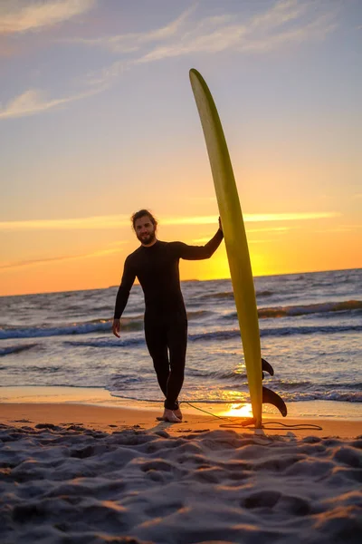 Бородатий серфер на пляжі під час заходу сонця — стокове фото