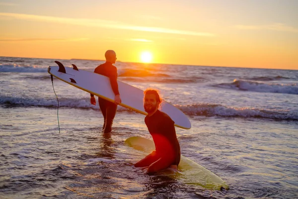 Surfisti irriconoscibili che entrano in mare ondulato — Foto Stock