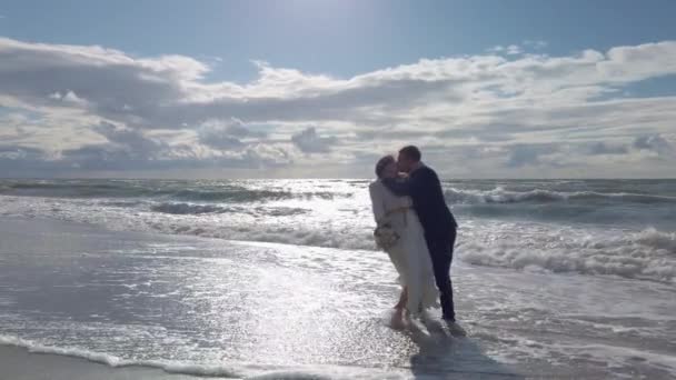 Sevgili yeni evli çift okyanus kenarında öpüşüyor. — Stok video