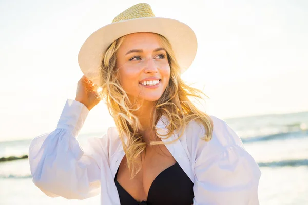 Bikini giyen ve plajda şapka takan mutlu bir kadın. — Stok fotoğraf
