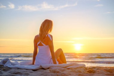 Gün batımında sahilde sakin bir kadın