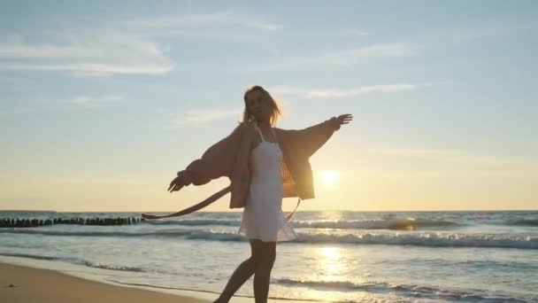 Gondtalan fiatal nő sétál a homokos tengerparton — Stock videók