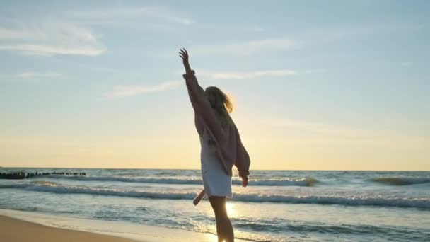 Gondtalan fiatal nő sétál a homokos tengerparton — Stock videók