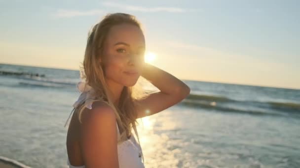 Zachte jonge vrouw genieten van zonsondergang in de buurt van zee — Stockvideo