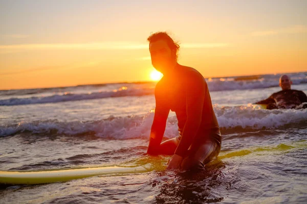 Surfer sitting on surfboard in sea — Stock Photo, Image