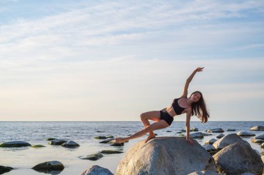 İnce kadın taşın üstünde Vahşi Şey pozu veriyor.