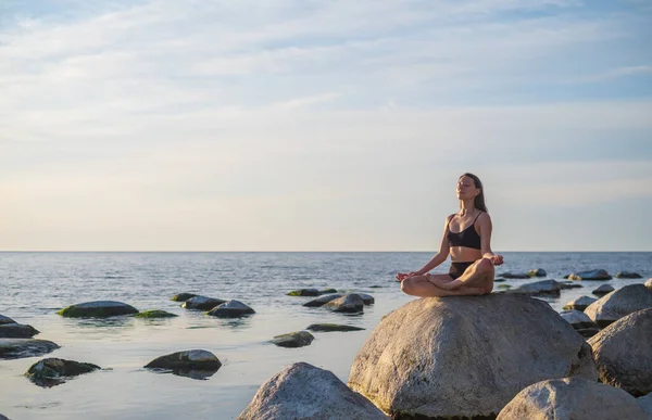 Молодая женщина медитирует у моря — стоковое фото