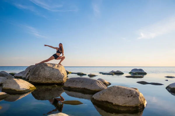 Smal kvinna gör Side Lunge på stenblock — Stockfoto