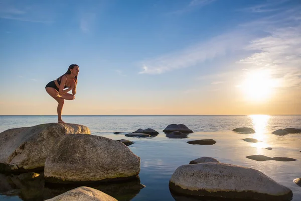 Passform kvinna balanserar på sten nära havet — Stockfoto