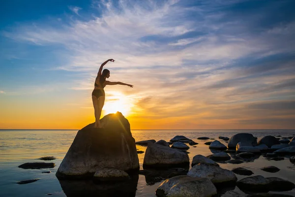 Mujer elegante bailando en la roca durante la puesta del sol — Foto de Stock