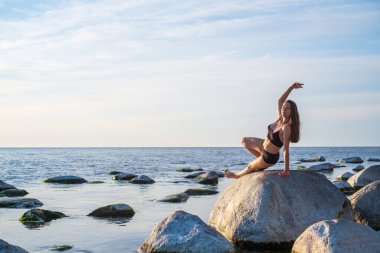 İnce kadın taşın üstünde Vahşi Şey pozu veriyor.