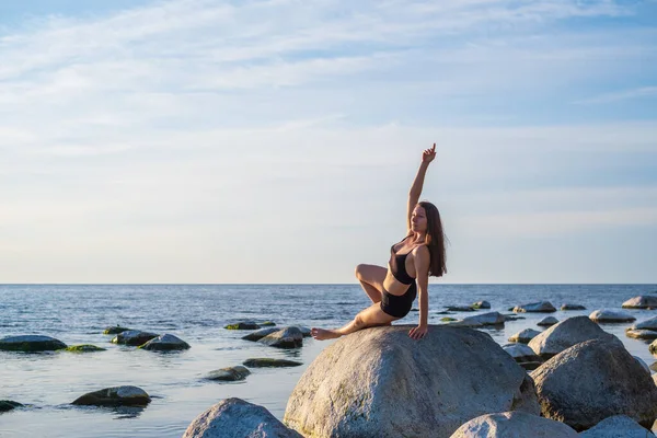 Mujer delgada haciendo Wild Thing pose sobre piedra — Foto de Stock