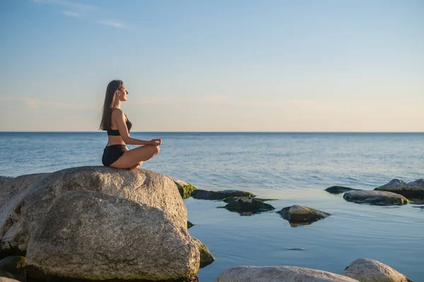 Mujer meditando en la noche cerca del mar — Foto de Stock