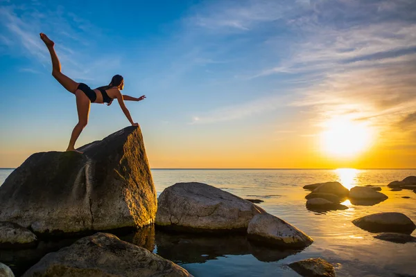 Mujer anónima balanceándose sobre piedra en pose de Guerrero — Foto de Stock