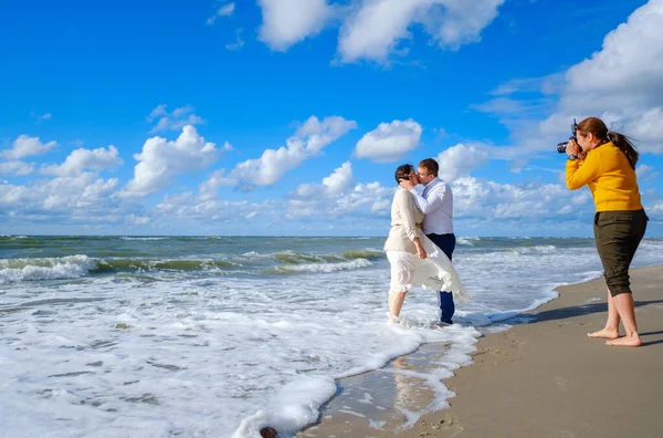 Fotógrafo tomando fotos de una pareja besándose cerca del mar —  Fotos de Stock