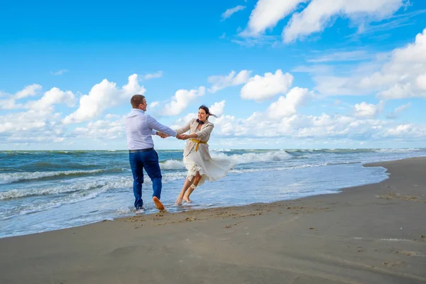 Šťastný pár tančí blízko vlnící se moře — Stock fotografie