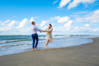 Deniz kenarında dans eden mutlu çift